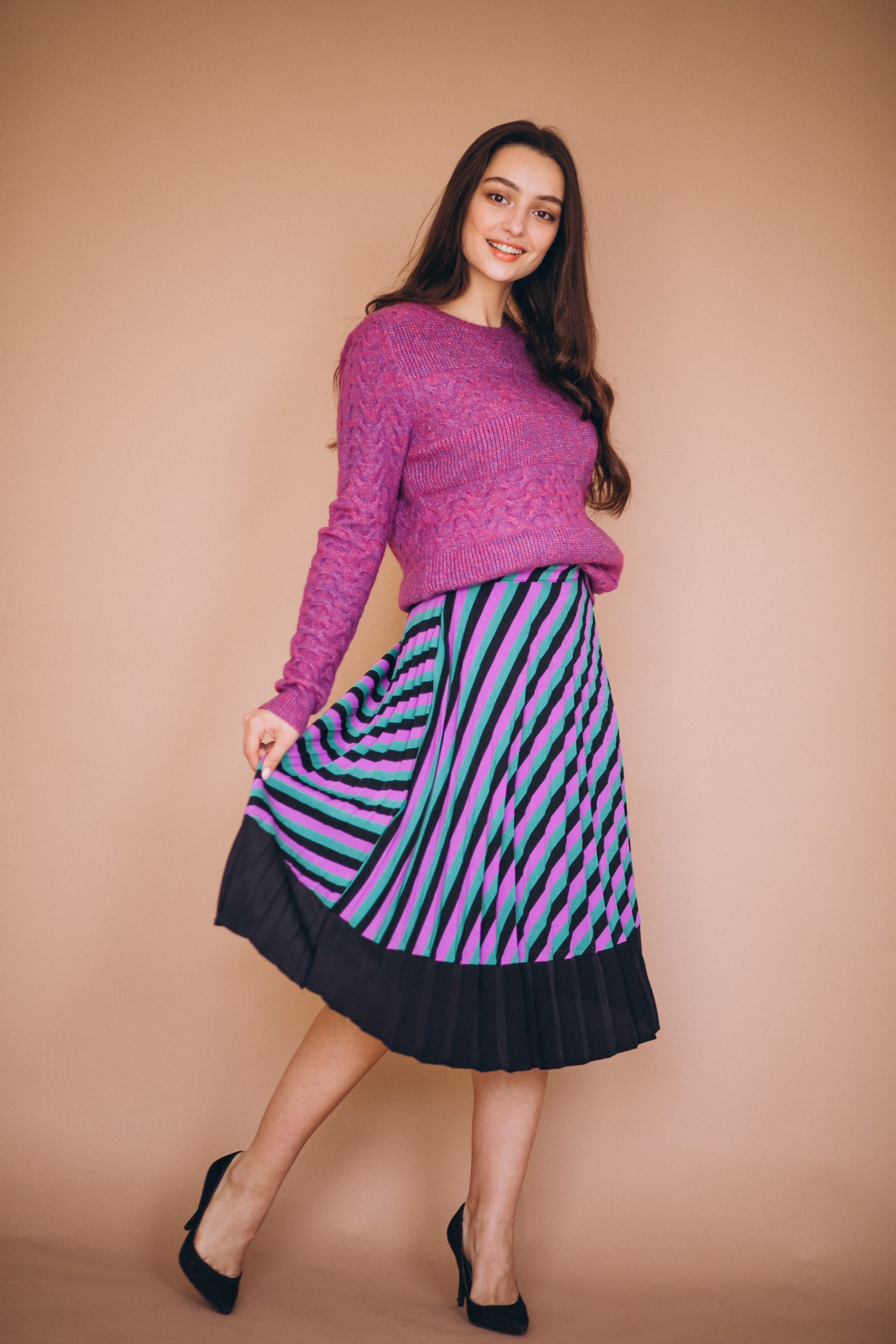 beautiful woman in a purple sweater and skirt in studio